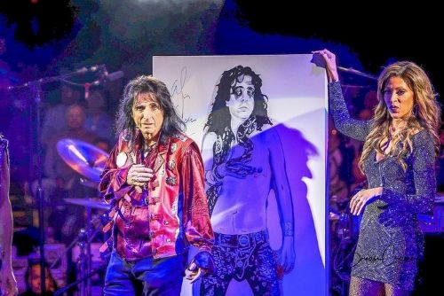 Guests participating in a live charity auction led by Subyn Novelle with Alice Cooper.